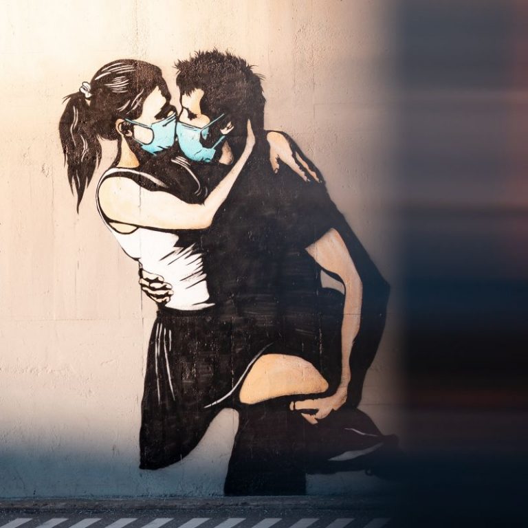 graffiti d'un couple s'embrassant fougueusement avec des masques de protection